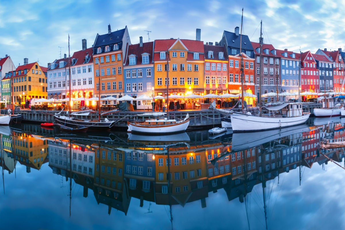 panorama shot of the nyhavn district of copenhagen with reflections of colorful buildings in the water